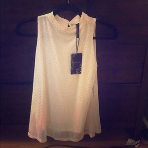 White with gold polka dots high collared top.